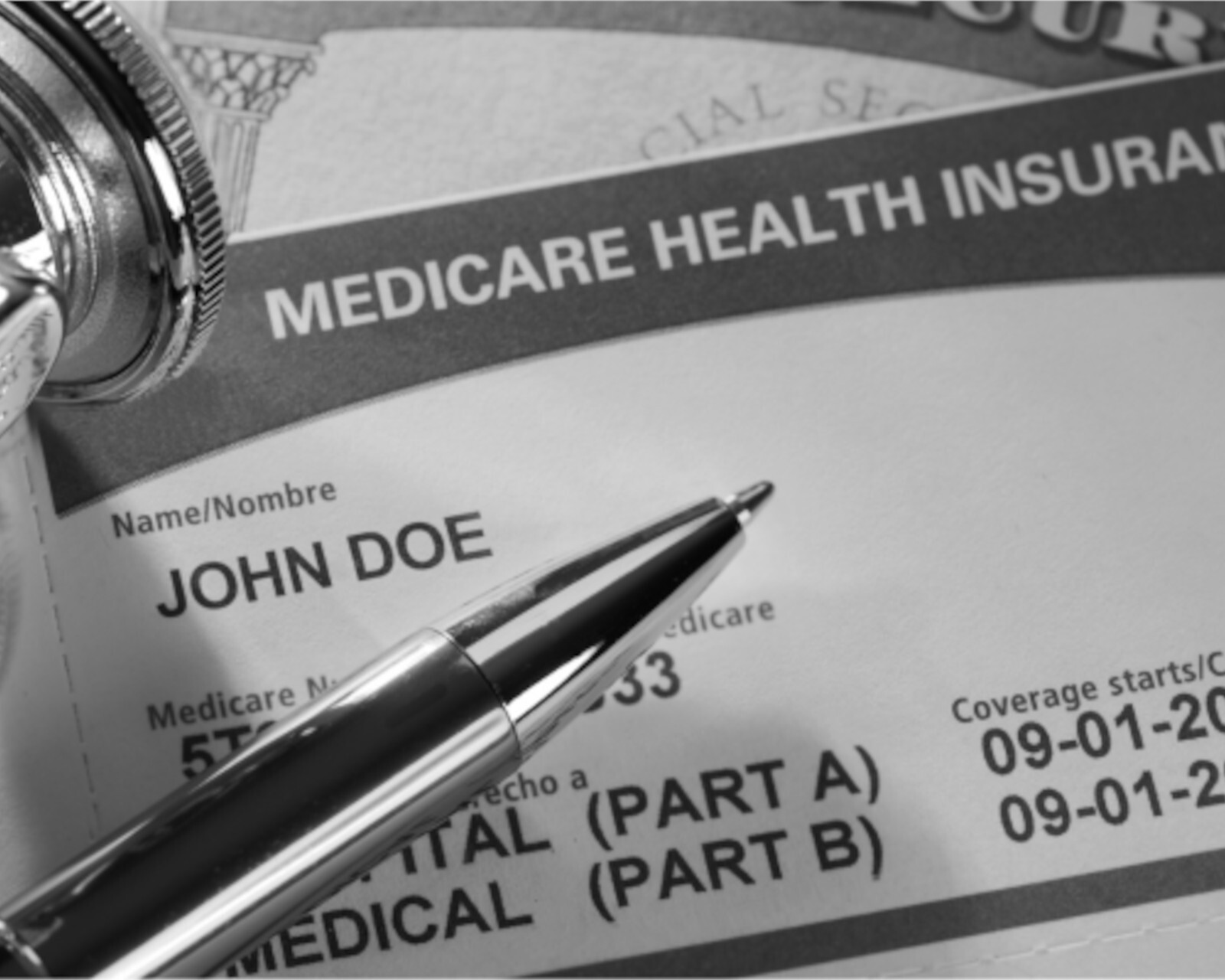 A Medicare health insurance card with a pen poised in front of it. The name on the card reads 