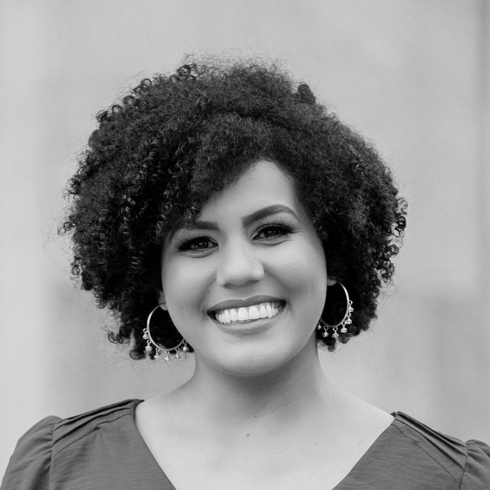 woman-curly-brown-hair-smiling-stock-headshot