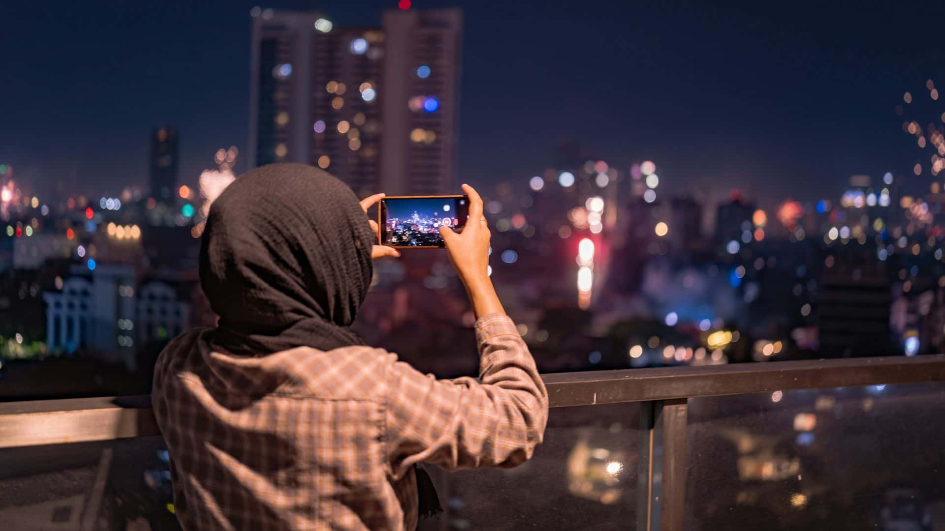 elx-stock-young-woman-using-phone-taking-photo-city-1920x1080